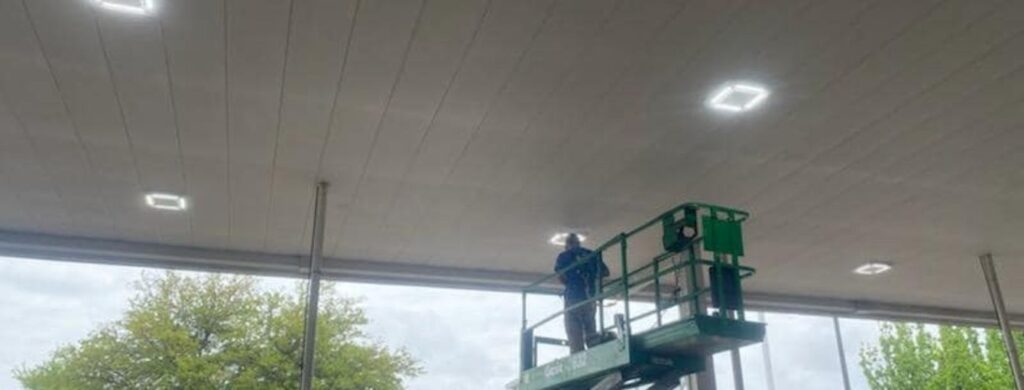 Installing parking lot lights on an overhang.